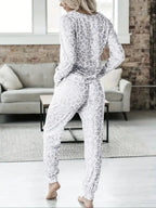 Women's V-NeckLeopard Print Loungewear Set. This relaxed-fit two-piece features a short-sleeve top and pants for effortlessly chic, casual comfort.