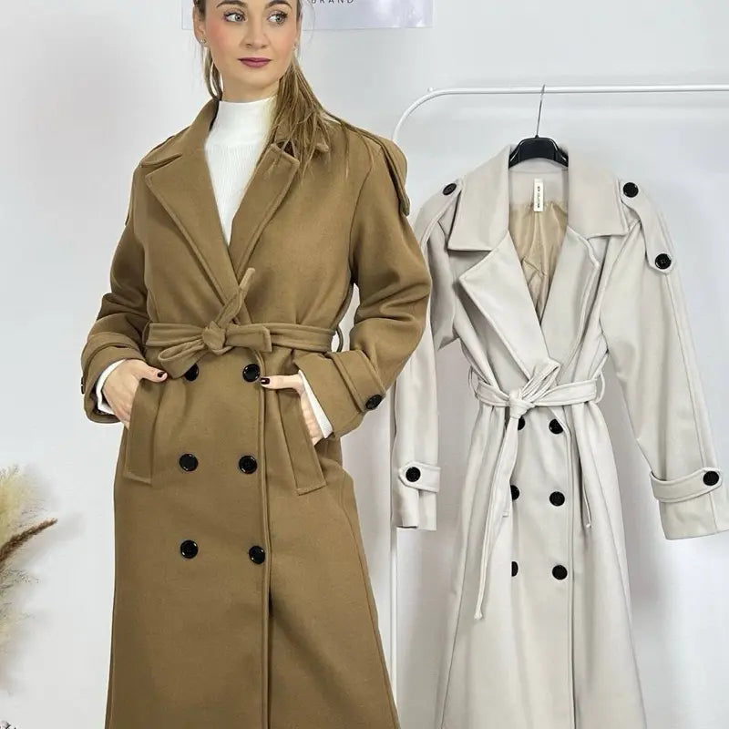 This double-breasted coat features button closure, a built-in belt, and practical pockets, showcasing refined elegance and versatile practicality