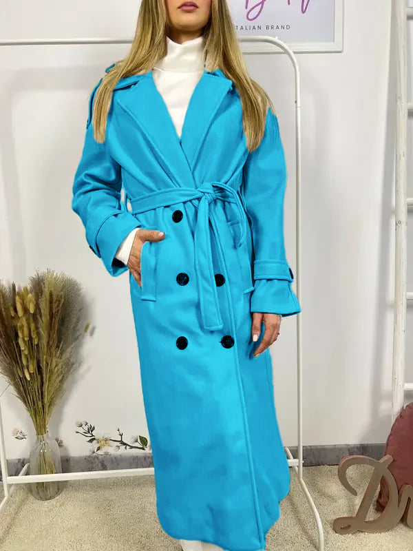 This double-breasted coat features button closure, a built-in belt, and practical pockets, showcasing refined elegance and versatile practicality