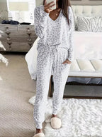Women's V-NeckLeopard Print Loungewear Set. This relaxed-fit two-piece features a short-sleeve top and pants for effortlessly chic, casual comfort.