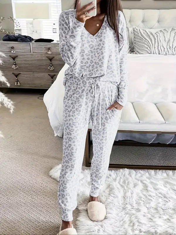 Women's V-NeckLeopard Print Loungewear Set. This relaxed-fit two-piece features a short-sleeve top and pants for effortlessly chic, casual comfort.