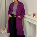 This double-breasted coat features button closure, a built-in belt, and practical pockets, showcasing refined elegance and versatile practicality