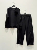 This two-piece wetsuit set, made of wetsuit viscose fabric, includes a shirt adorned with a flower brooch and a pair of elasticated harem pants.
