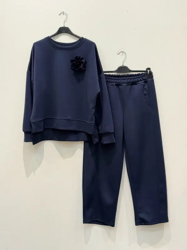 This two-piece wetsuit set, made of wetsuit viscose fabric, includes a shirt adorned with a flower brooch and a pair of elasticated harem pants.