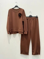 This two-piece wetsuit set, made of wetsuit viscose fabric, includes a shirt adorned with a flower brooch and a pair of elasticated harem pants.