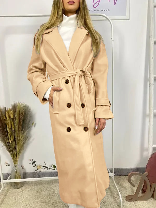 This double-breasted coat features button closure, a built-in belt, and practical pockets, showcasing refined elegance and versatile practicality